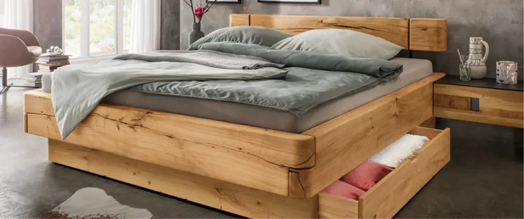 Modernes Massivholzbett mit integriertem Bettkasten und grauer Bettwäsche in stilvollem Schlafzimmer mit Wandbildern und dekorativer Beleuchtung